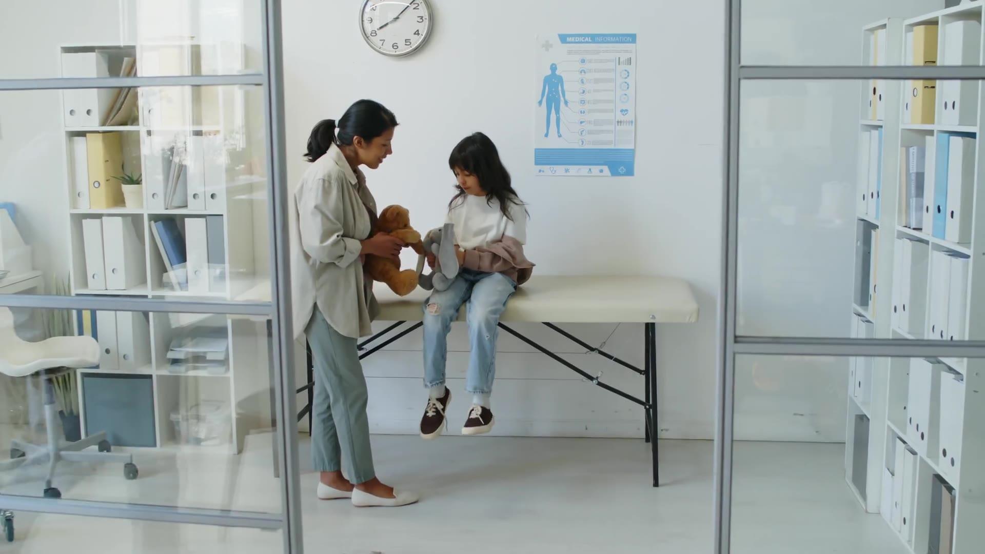 A mother and daughter in a bright clinic exam room, from the healthcare concept