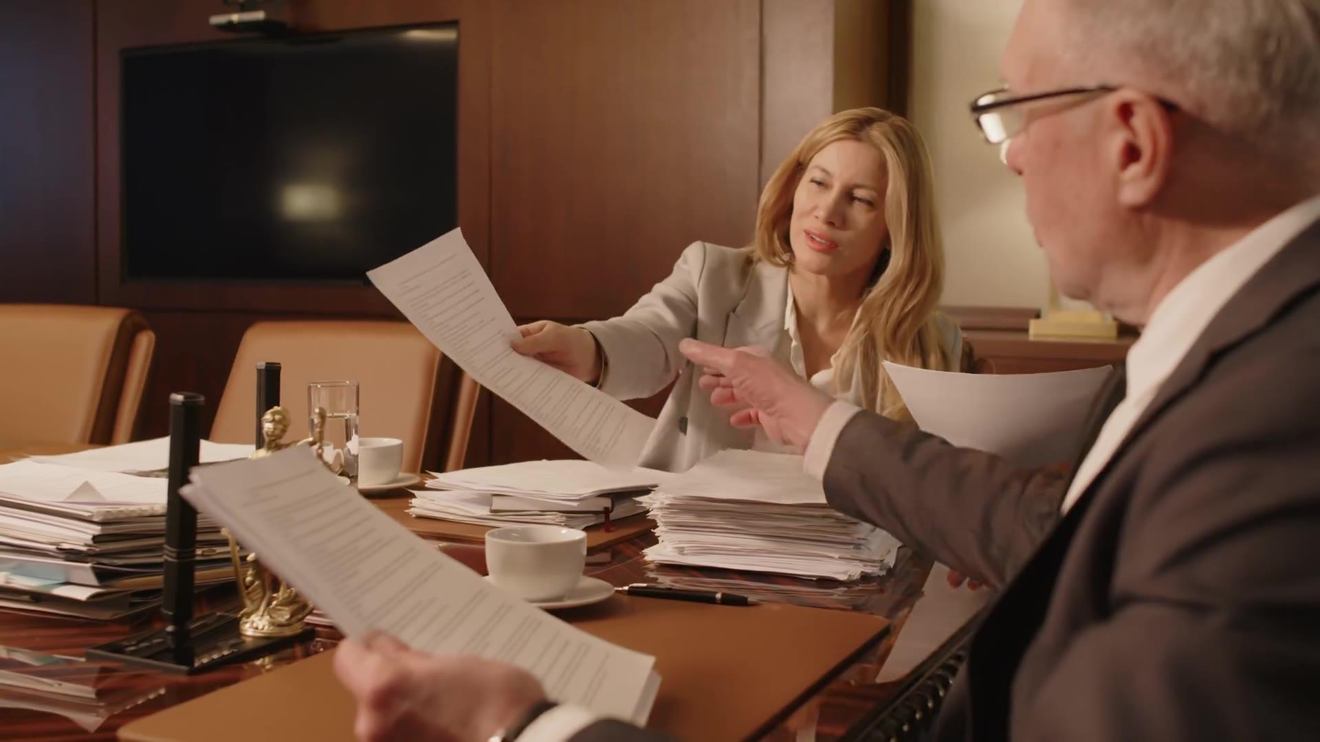Attorneys reviewing documents in a wood-paneled office, from the law firm concept