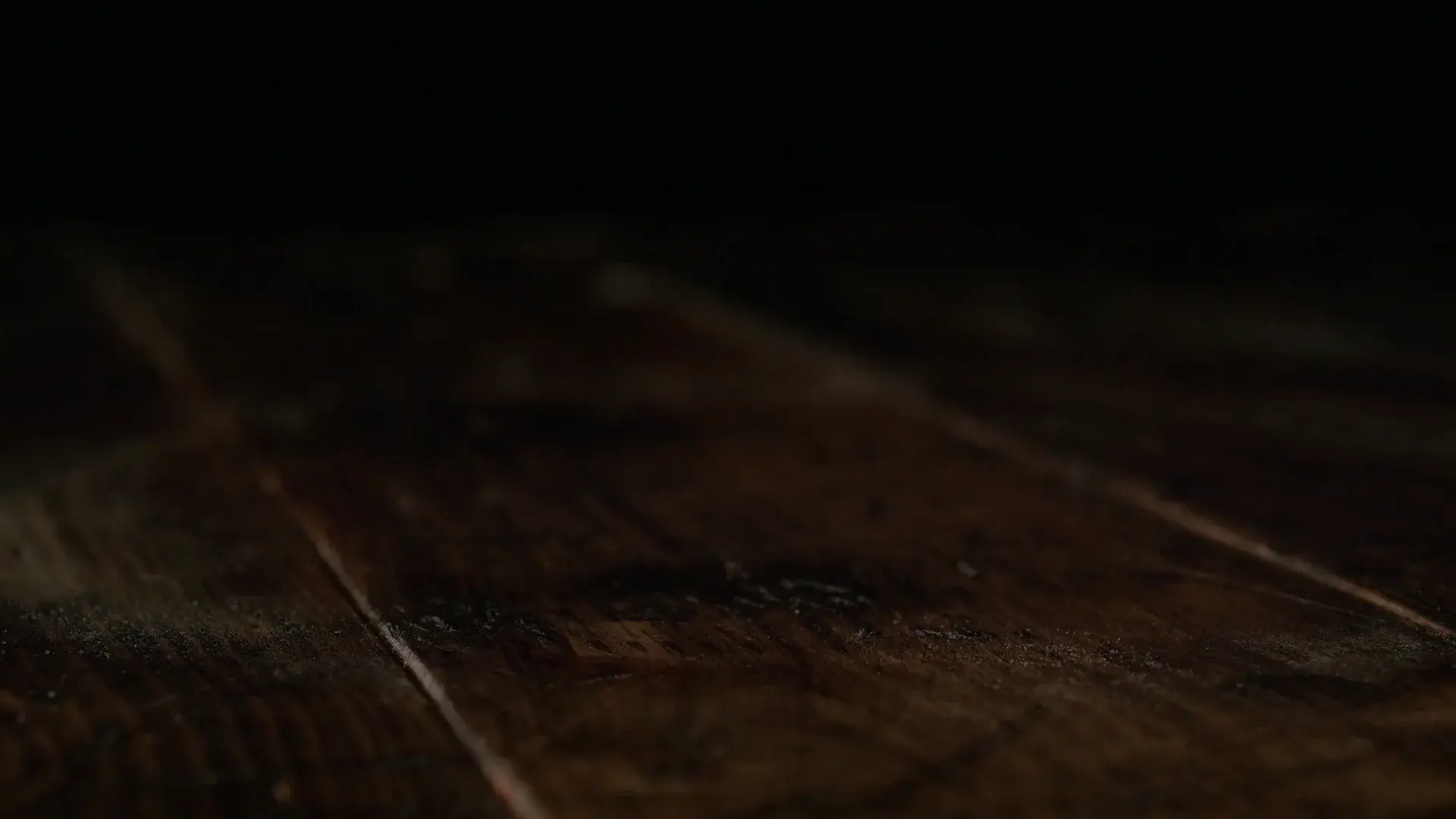 A pepperoni pizza on a dark wood table